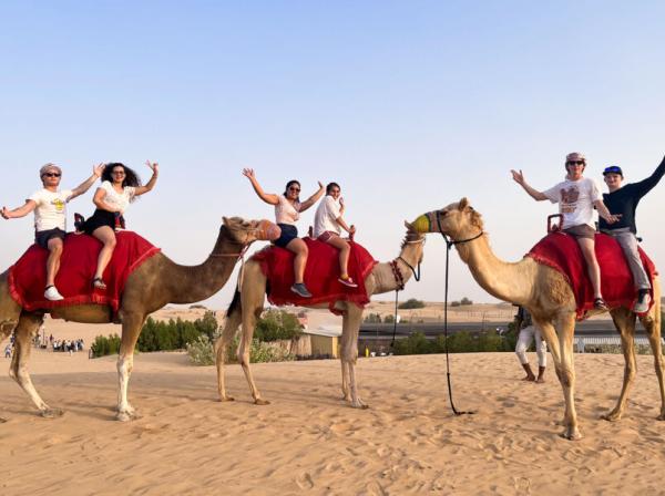 Six students ride three camels on a study abroad trip.