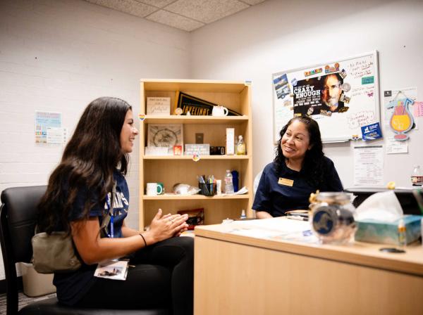 Success coach advises student in university office.