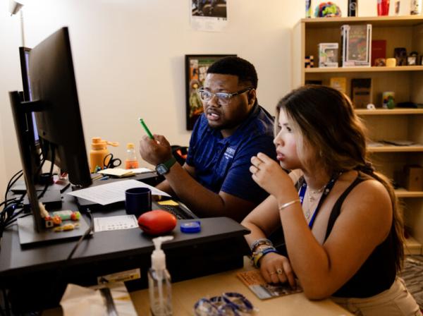 A student and advisor walk through registering for classes