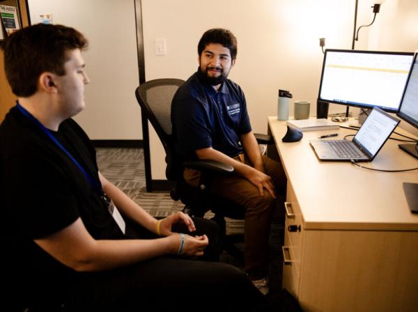 A student meets with a success coach in their office.