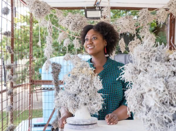 Tammie Rubin stands with her art in an outdoor studio.