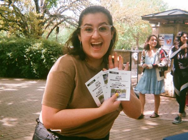 A student holds flyers on campus.