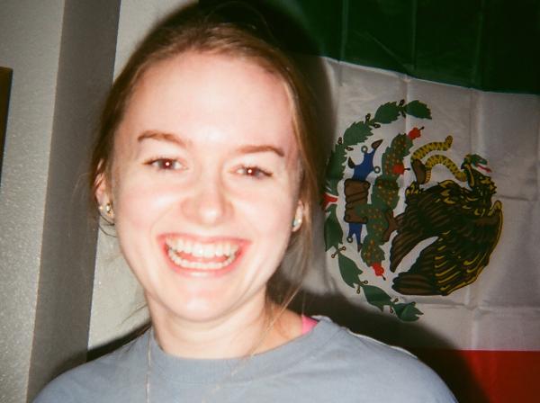 Celine Cottenoir smiles. A Mexican flag is in the background.