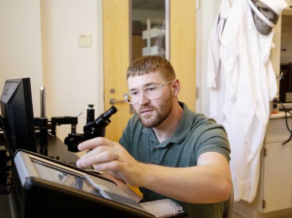 Professor Matthew Steffenson works with equipment in a research lab.