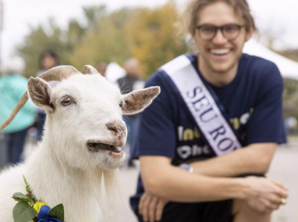 homecoming campus mascot goat on campus with a student 