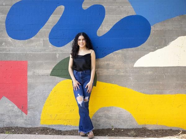 Ruvi Jaimes stands in front of a colorful mural on South Congress.