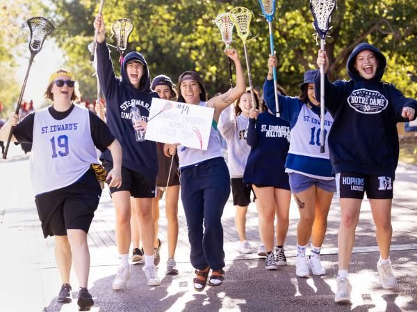 Members of the women's lacrosse club sports team march in the homecoming parade.