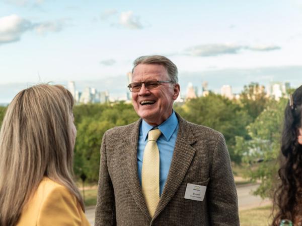 Alumni with a name tag chatting at an event on campus 