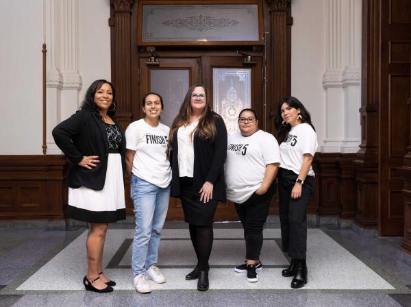 Leah Pinney, center, stands her staff members in the Texas State Capitol.