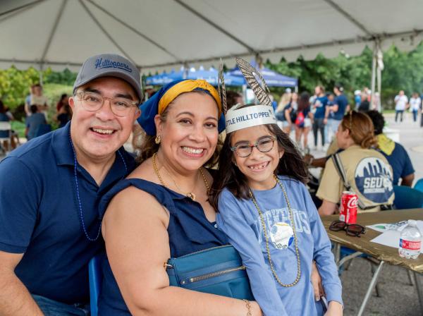 A family wearing blue and gold at homecoming.