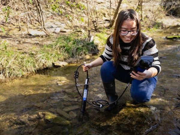 A biology student works in the field