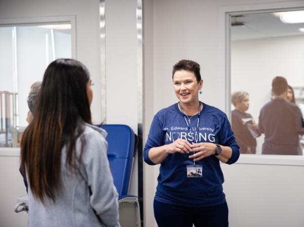 Donna Beuk talks to a student in the nursing labs