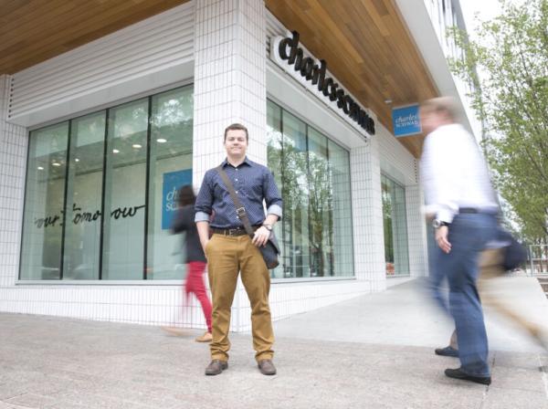 student at a downtown street corner during an internship 