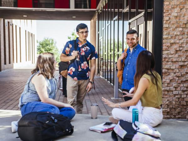 Four students at St. Edward's visit outside the Residential Village 