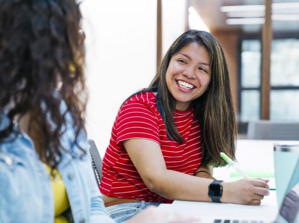 student in a red shirt writing 