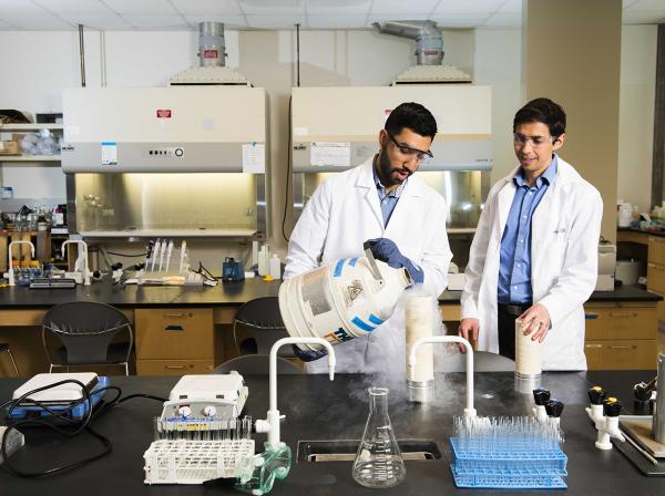 A student and a professor work in a chemistry lab.