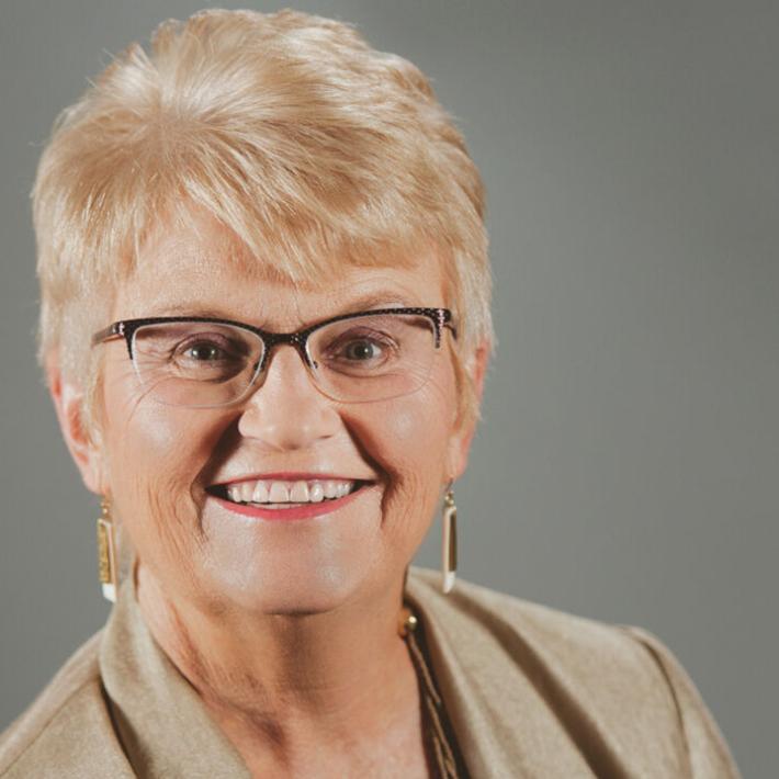 Close-up headshot of a blonde woman with glasses