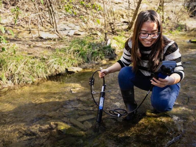 A biology student works in the field