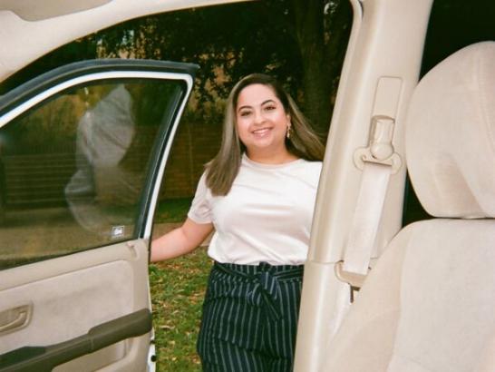 Myrka Moreno smiling from outside an open car door