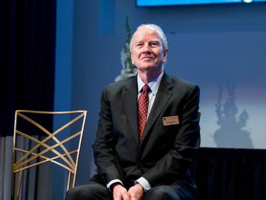 Dr. George Martin sitting on a stage