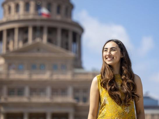 St. Edward's student Michelle Flores stands in front of the Texas Capitol building, where she is interning.