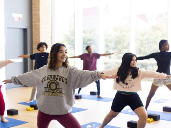 Students participate in a yoga class in the fitness studio. 