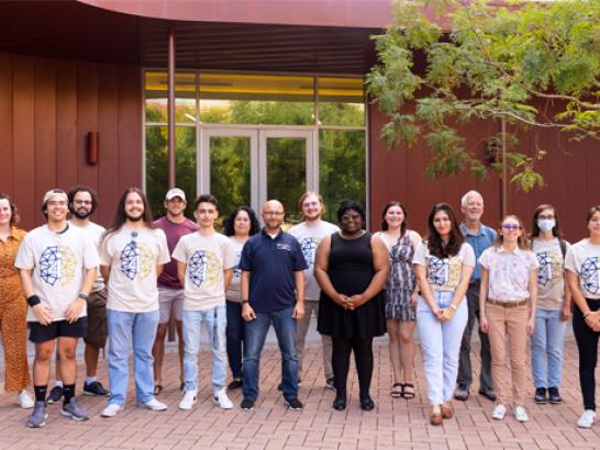 St. Edward's University's i4 students pose for a group photo behind John Brooks Williams Natural Sciences Center South.