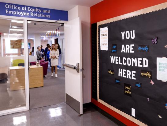 The entrance to the Office of Equity and Employee Relations. A bulletin board outside the office reads YOU ARE WELCOMED HERE.