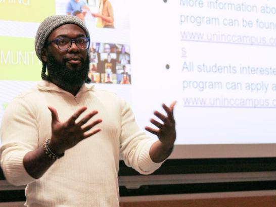 Student pitches his business plan to a panel and peers.