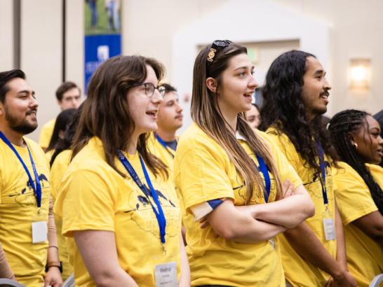 Transfer students wear matching yellow shirts and participate in an orientation activity.