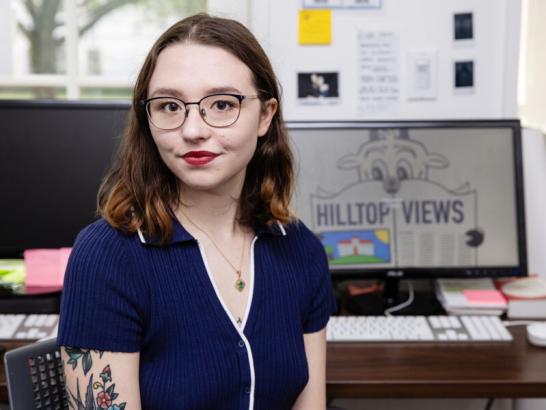 The Hilltop Views editor-in-chief sits at a desktop computer in the Hilltop Views newsroom.