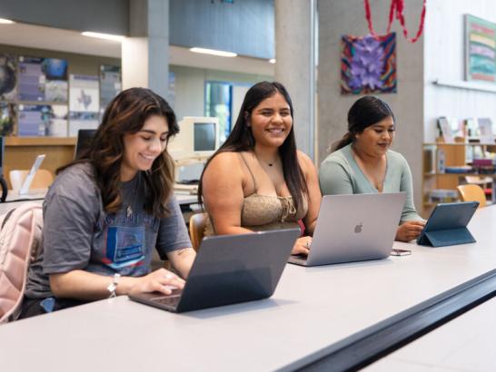 Three students studying in the Munday Library