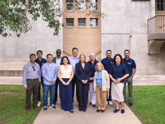 Business faculty and staff stand outside of The Bill Munday School of Business.