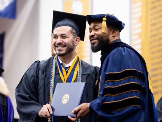 Graduating senior receives diploma at commencement.