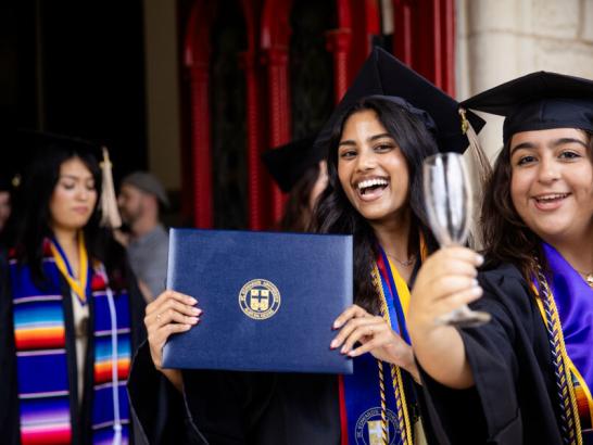 Graduating senior walking through the Red Doors at Main Building during the Legacy Walk.