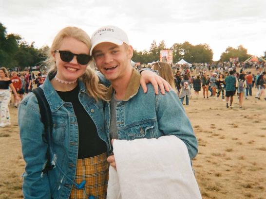 A man and a woman wearing denim jackets posing for the camera