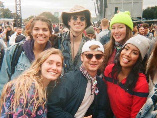 A group of 6 friends posing in front of a large crowd