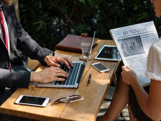 A student and professor gather around a table to discuss career opportunities.