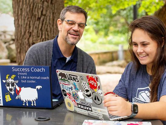 Success coach advising student on laptop