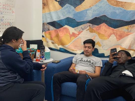 Three students hanging out in a dorm