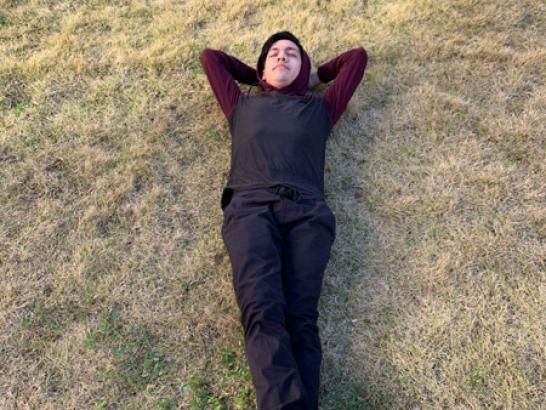 A student lying down in the grass