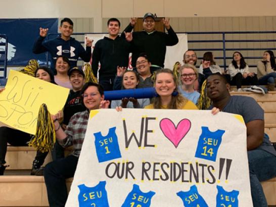 A group of RA's holding a big sigh that reads "We Heart Our Residents"