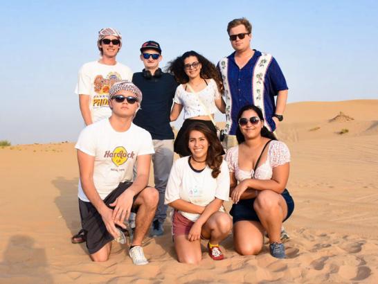 Students posing in a desert while studying abroad in Dubai