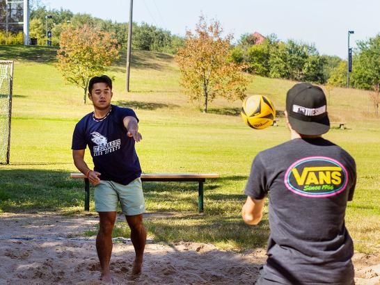 Students playing sand volleyball adjacent to Teresa Recreation field in the central of the St. Edward's University campus