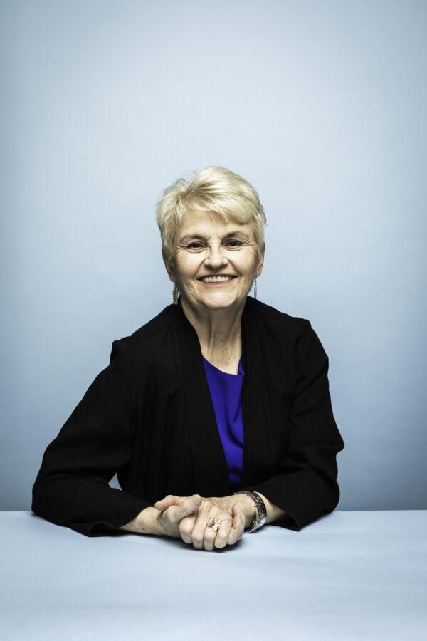 A portrait of Glenda Ballard sitting in front of a light blue backdrop.