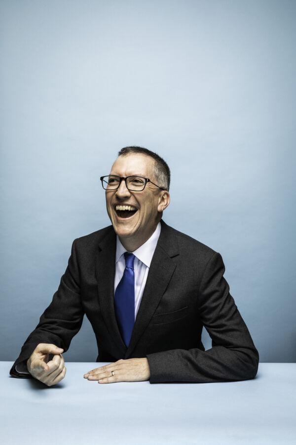 A portrait of Gary Morris sitting in front of a light blue backdrop.