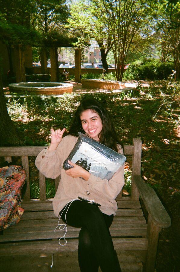 Patricia Medina gives a toppers up handsign as she sits on a bench on campus.