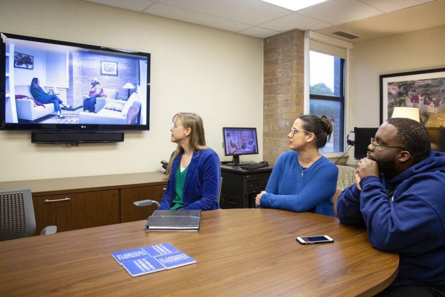 Counselors watching a recorded session via a tv feed