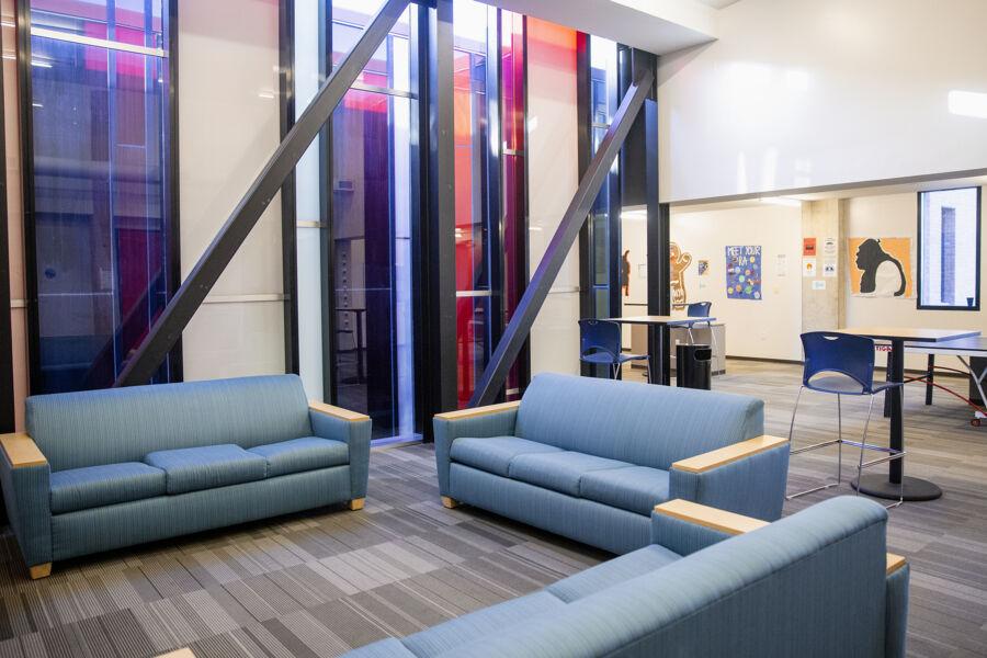 A spacious, well-lit room with blue sofas and floor-to-ceiling windows