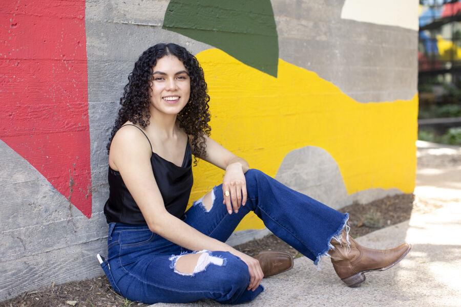 Ruvi Jaimes sits in front of a colorful mural on South Congress Avenue.